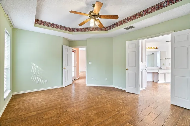 an empty room with a window and a ceiling fan
