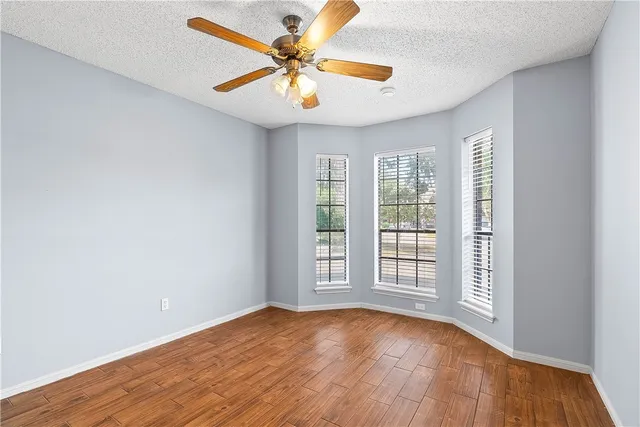 an empty room with a window and a ceiling fan