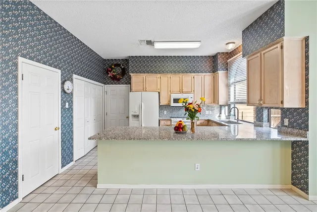 a kitchen with a sink a window and cabinets