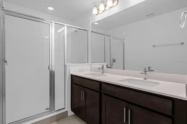 a bathroom with a double vanity sink and a mirror