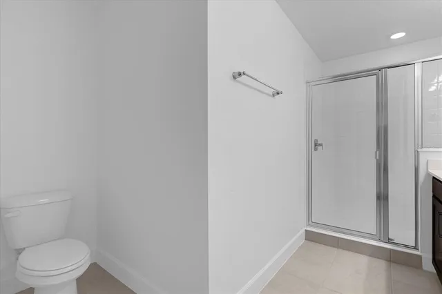 a bathroom with a granite countertop toilet and a shower