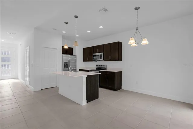 a large white kitchen with a refrigerator a stove top oven a sink and dishwasher