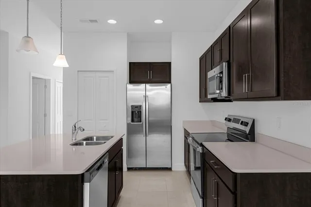 a kitchen with kitchen island a sink stainless steel appliances and cabinets