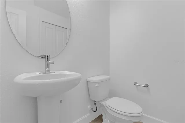 a bathroom with a toilet a sink and mirror