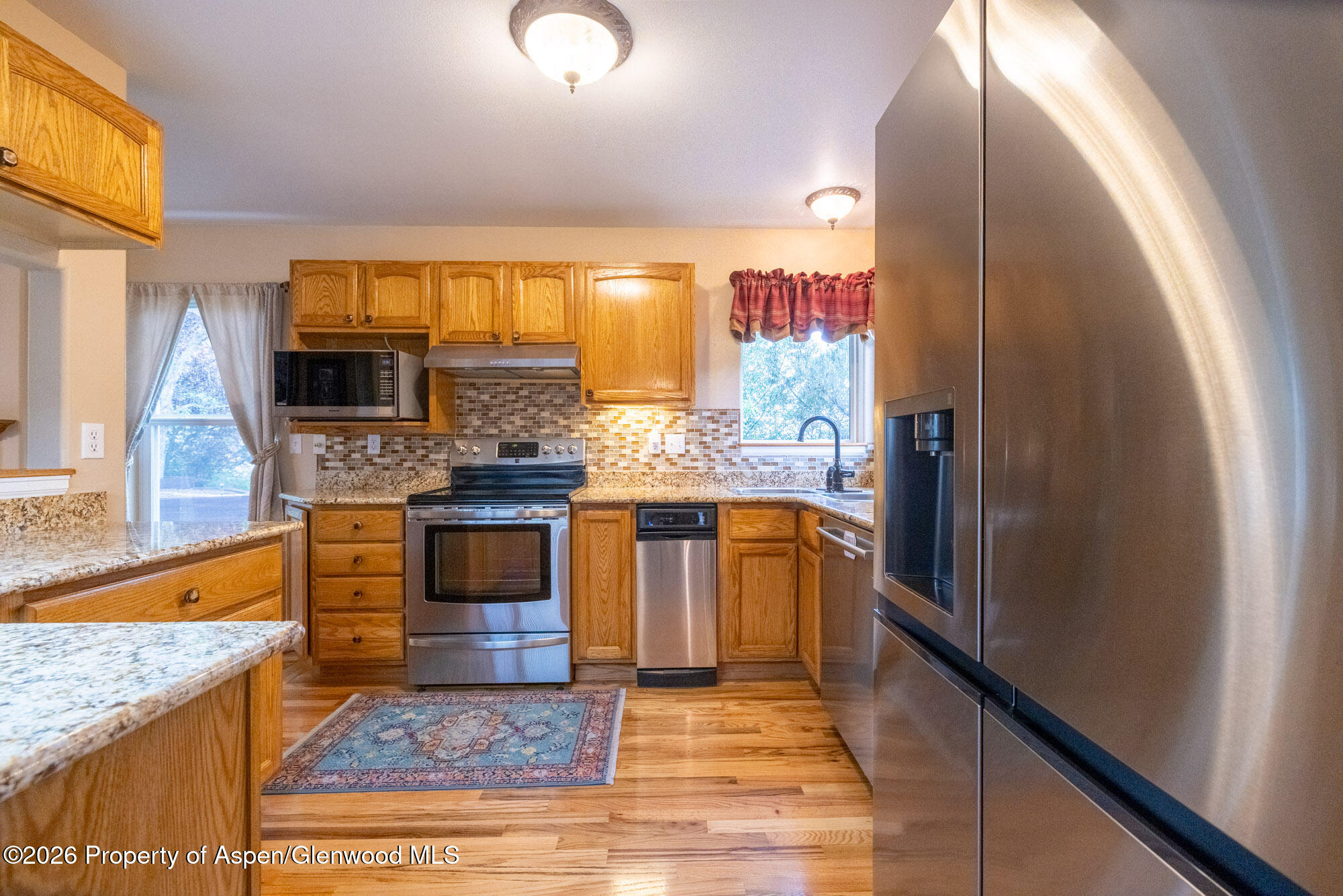 1335 Firethorn Drive Rifle, CO 81650 - Photo 5 of 30 a kitchen with stainless steel appliances granite countertop a stove a sink and a refrigerator