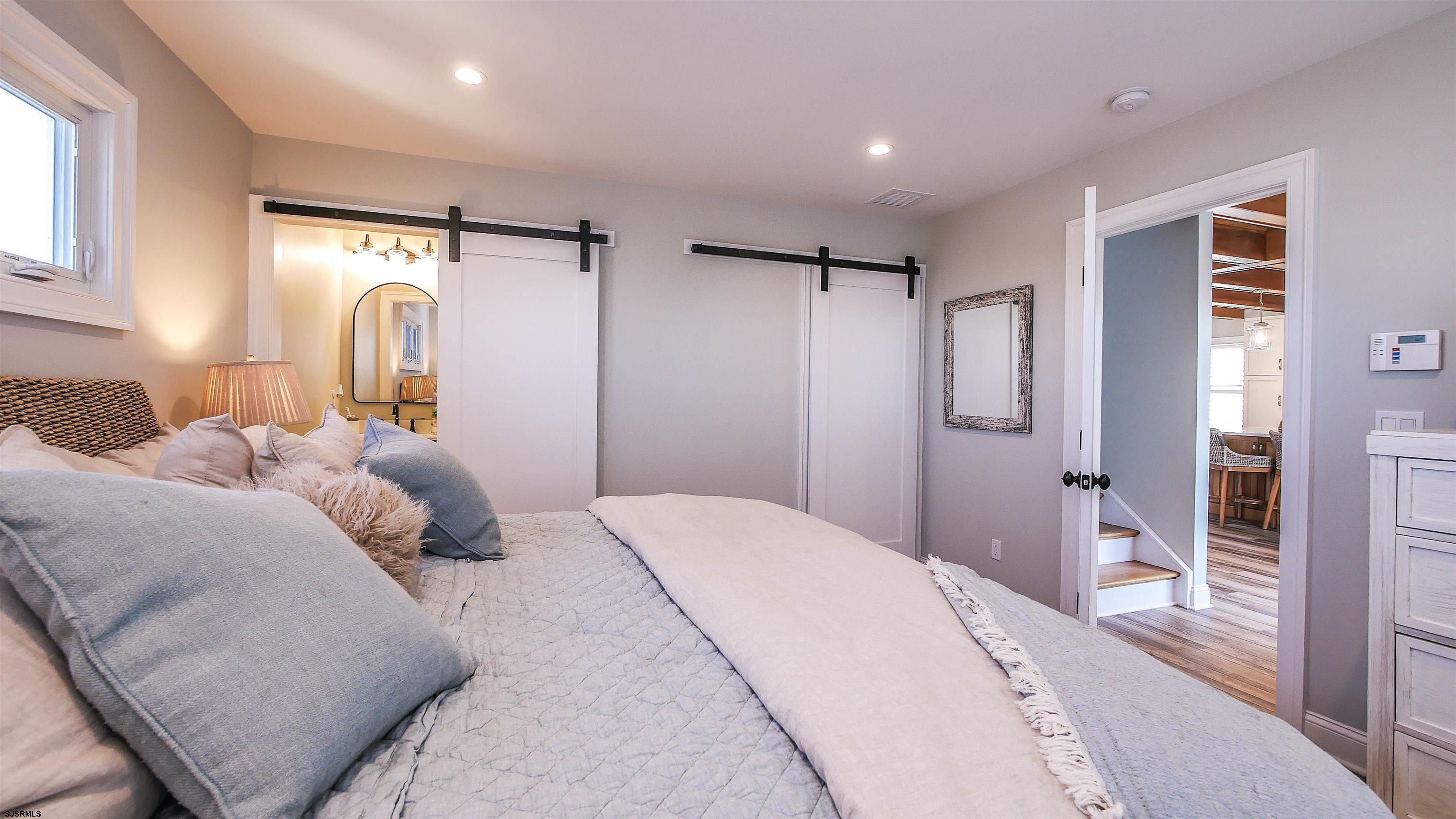 9 Commonwealth Avenue Strathmere, NJ 08248 - Photo 36 of 51 a spacious bedroom with a bed and a large mirror