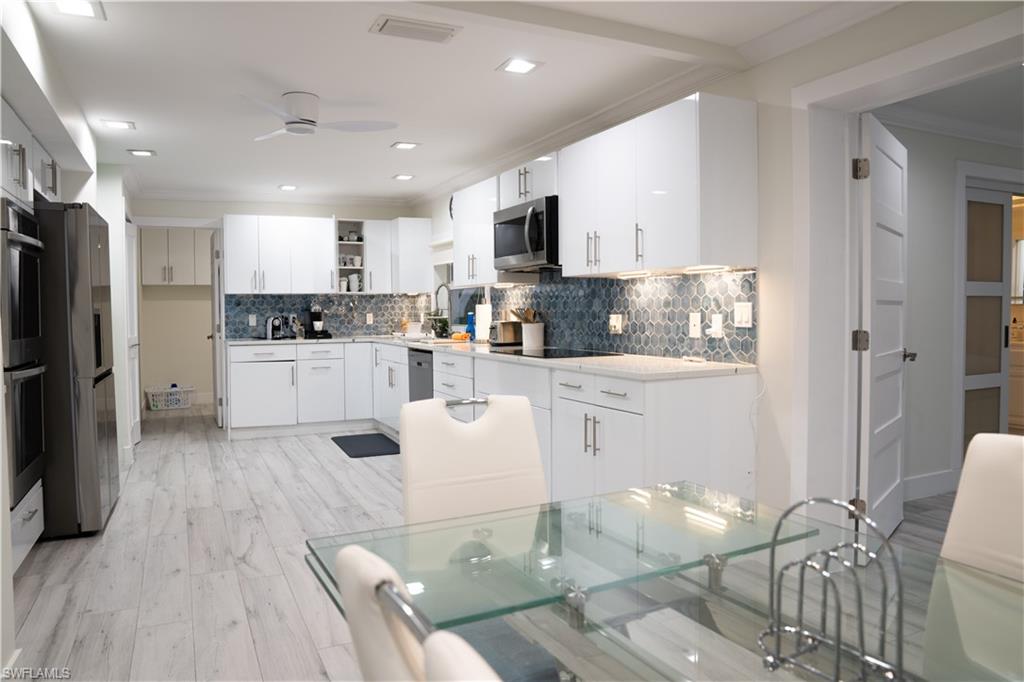 675 18th Avenue South Naples, FL 34102 - Photo 20 of 34 a kitchen with stainless steel appliances kitchen island granite countertop a refrigerator and microwave