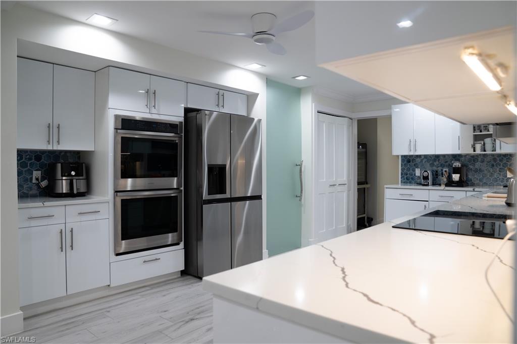 675 18th Avenue South Naples, FL 34102 - Photo 25 of 34 a kitchen with stainless steel appliances a refrigerator sink and microwave