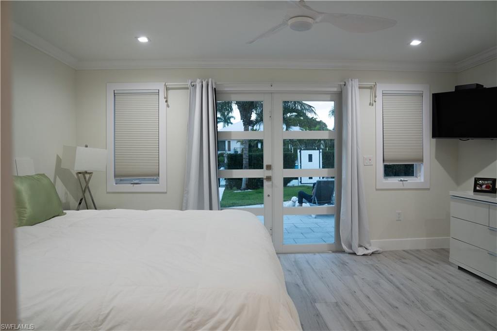675 18th Avenue South Naples, FL 34102 - Photo 31 of 34 a bedroom with a bed and glass door
