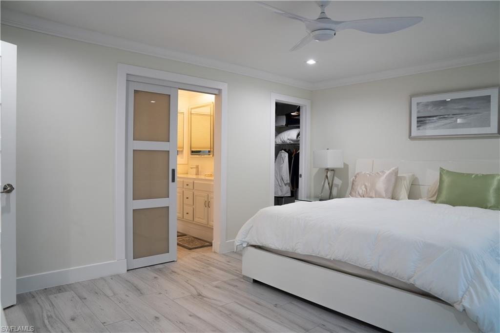 675 18th Avenue South Naples, FL 34102 - Photo 33 of 34 a bedroom with a large bed and wooden floor