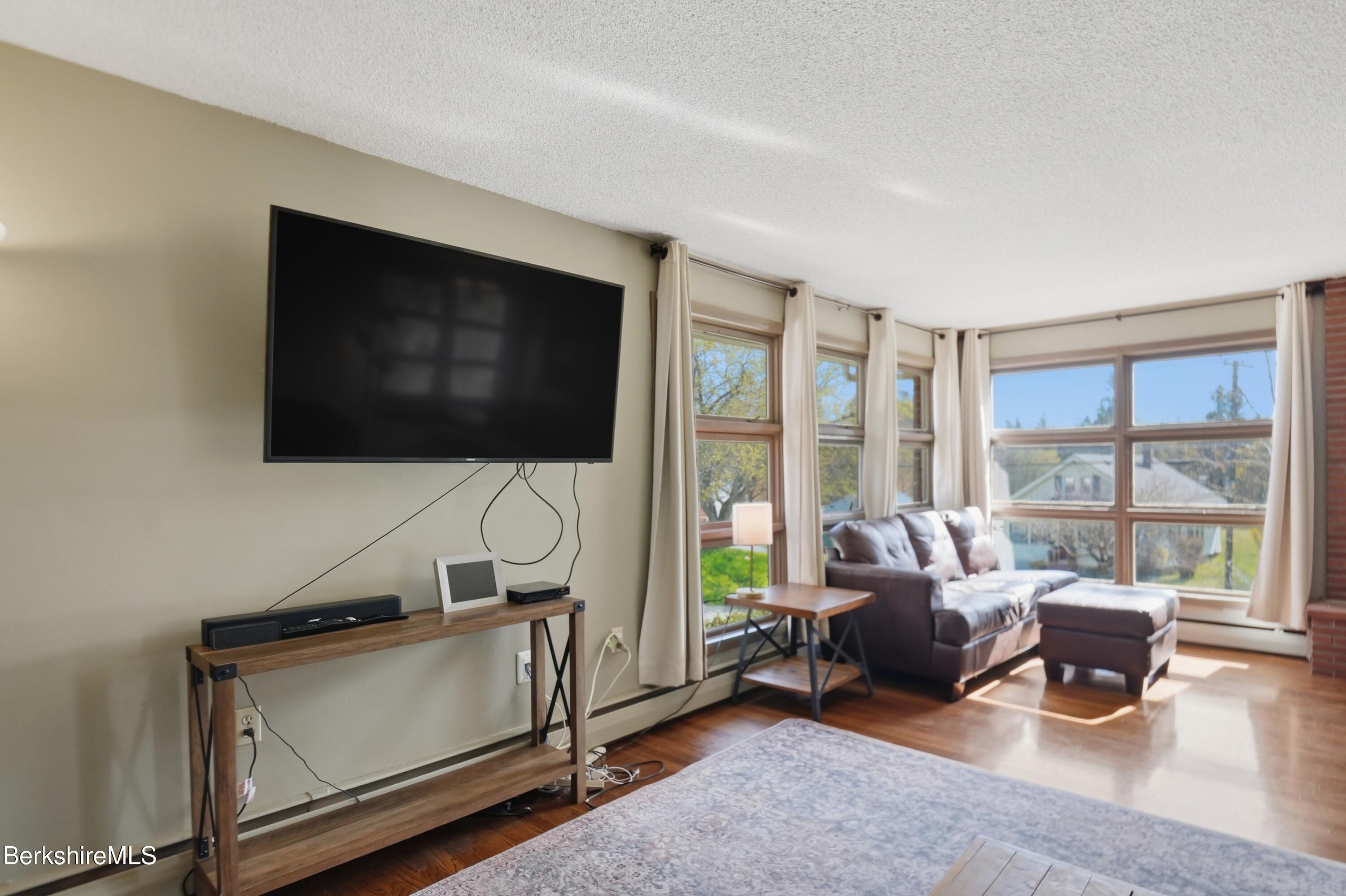 55 Tower Road Dalton, MA 01226 - Photo 12 of 47 a living room with furniture tv and a floor to ceiling window