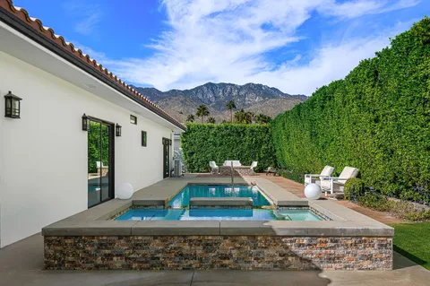 a view of a patio with couches table and chairs and potted plants
