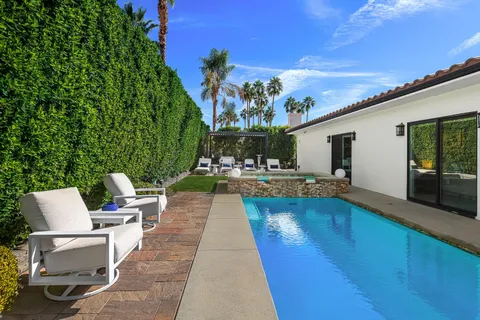 a backyard of a house with table and chairs