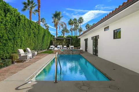 a view of patio with couches table and chairs with potted plants