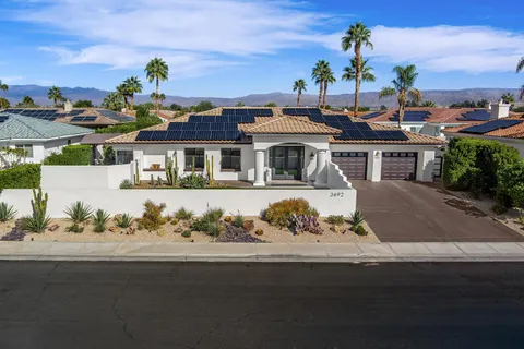 a view of balcony with furniture and a garden