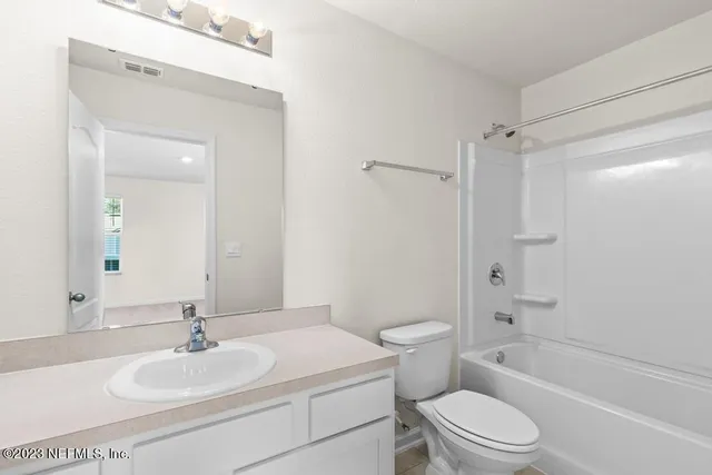 a bathroom with a toilet a sink a mirror and vanity