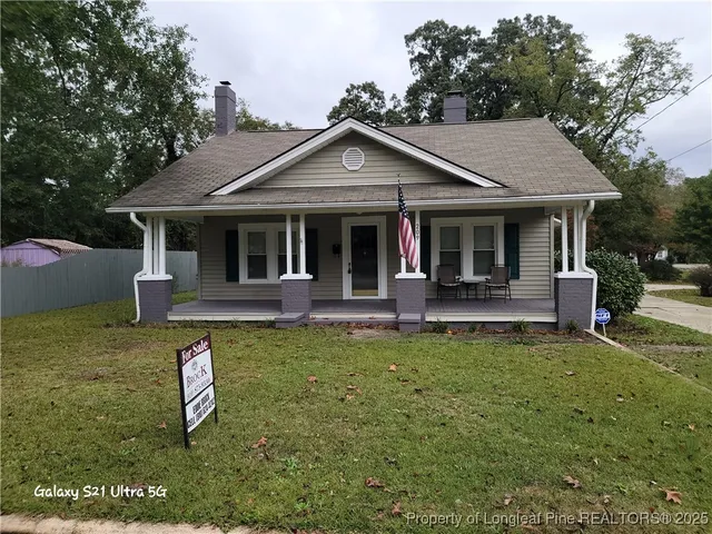 a view of a house with backyard and porch