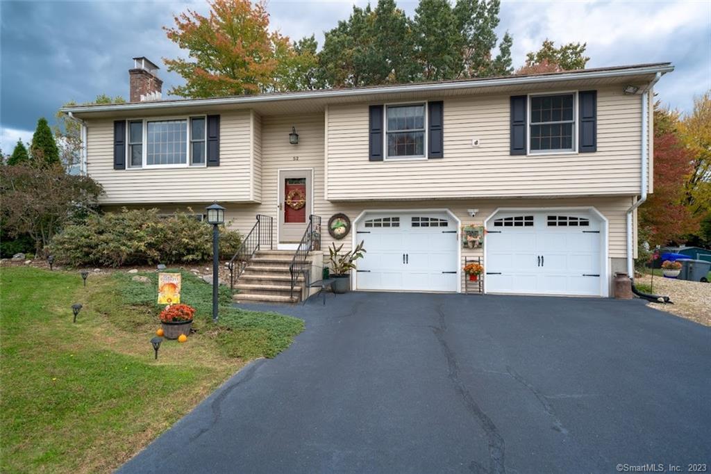 a view of a house with a yard and a garage