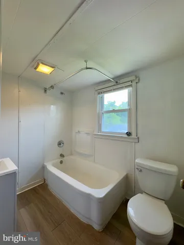 a white toilet sitting next to a bathtub