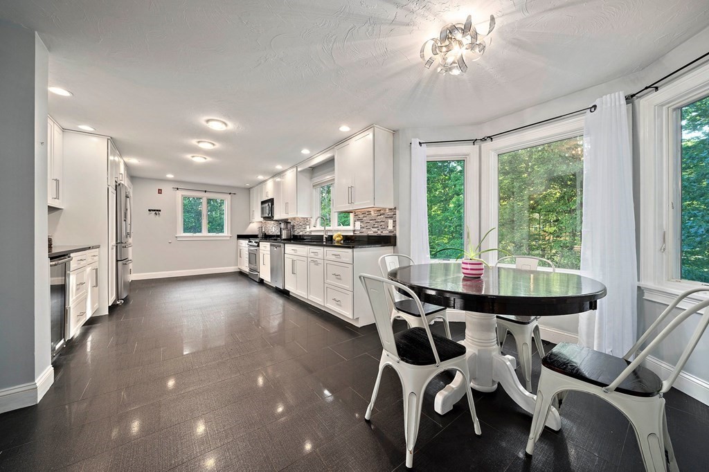 22 Fairview Road Canton, MA 02021 - Photo 14 of 42 a kitchen with stainless steel appliances kitchen island granite countertop a table chairs sink and cabinets