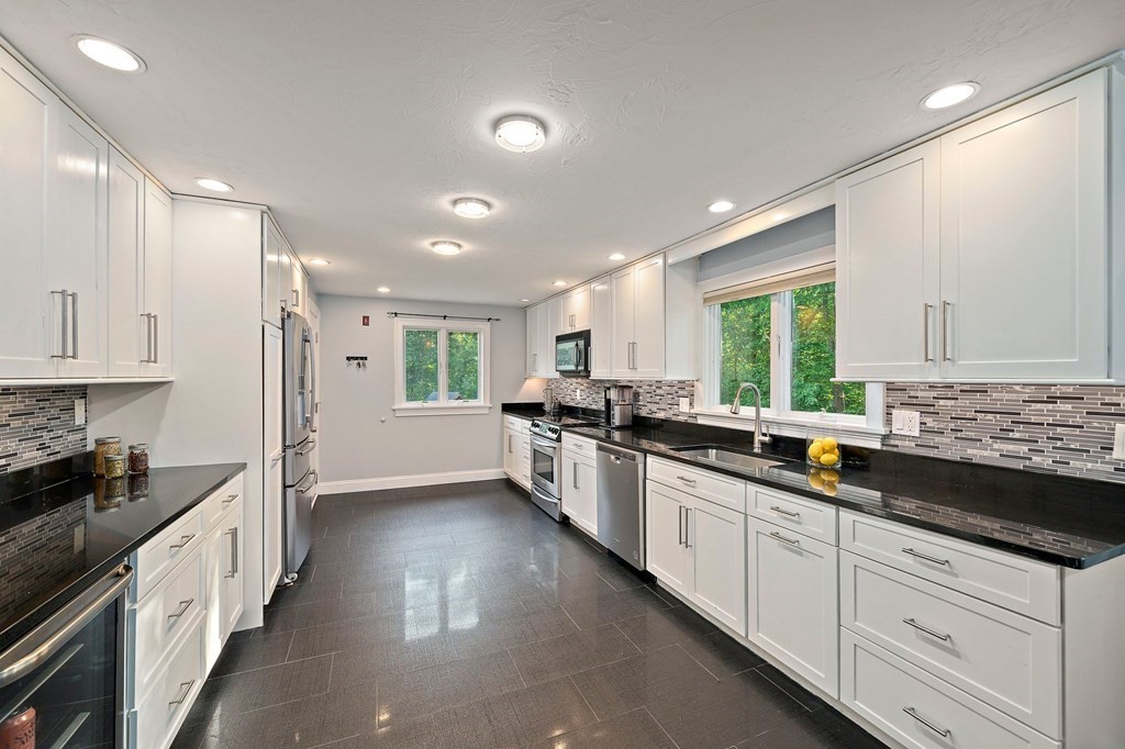 22 Fairview Road Canton, MA 02021 - Photo 15 of 42 a kitchen with counter top space a sink stainless steel appliances and cabinets
