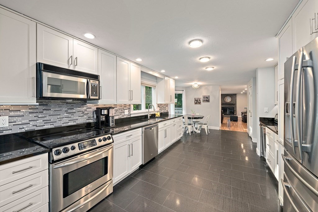 22 Fairview Road Canton, MA 02021 - Photo 17 of 42 a large white kitchen with stainless steel appliances granite countertop a stove a sink a refrigerator and white cabinets