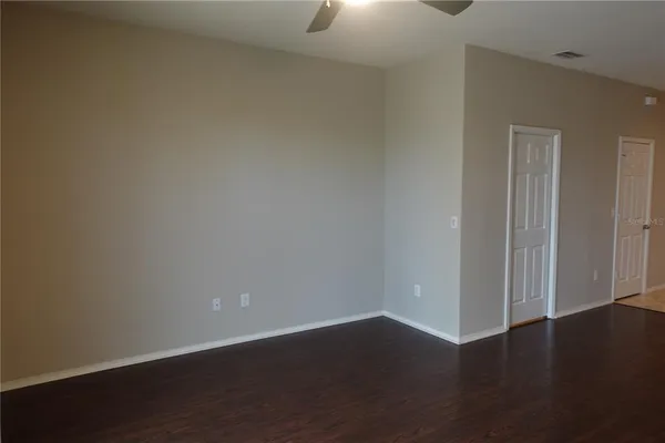 a view of an empty room with wooden floor