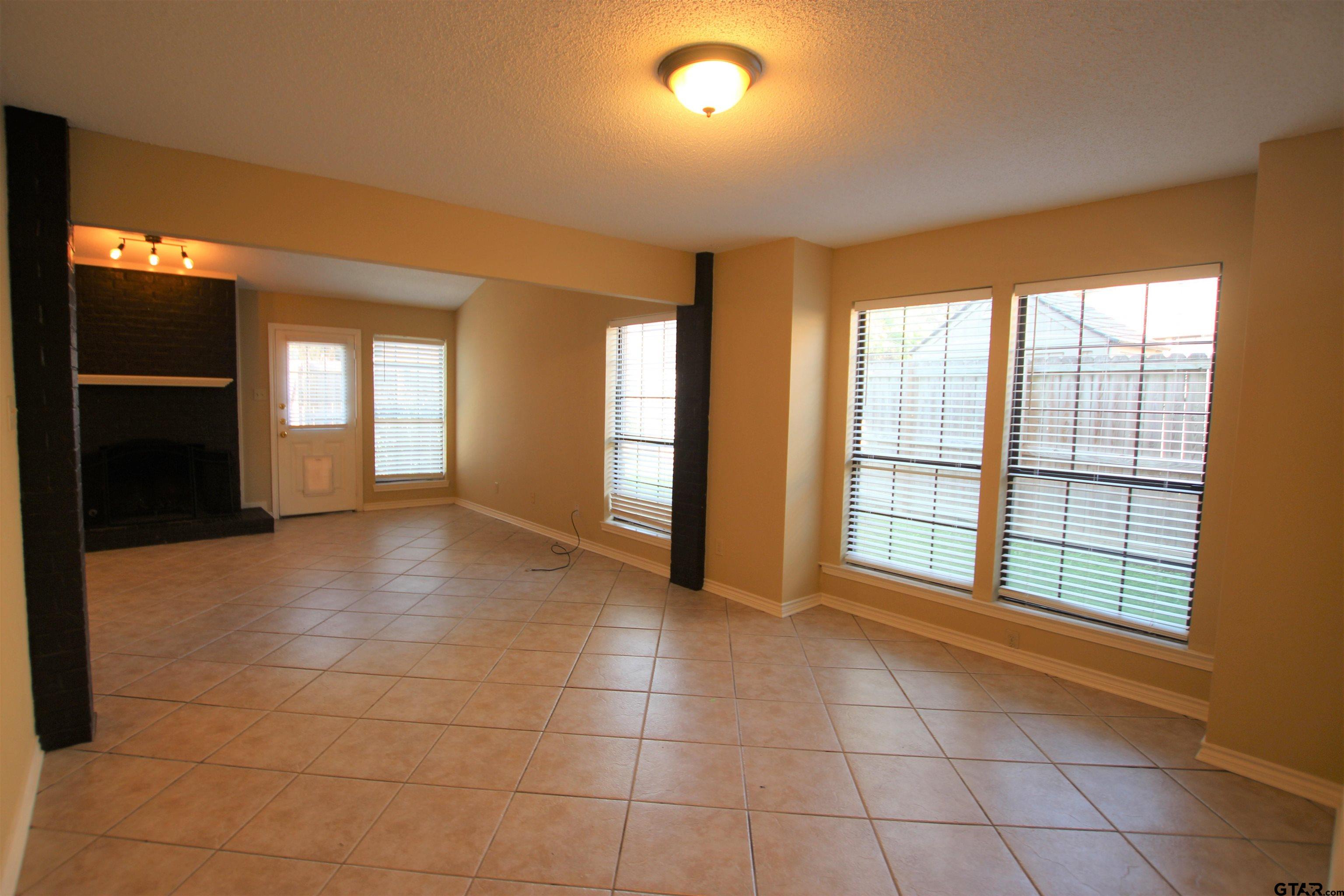 5875 Creekside Circle Tyler, TX 75703 - Photo 7 of 32 a view of an empty room with a fireplace and a window