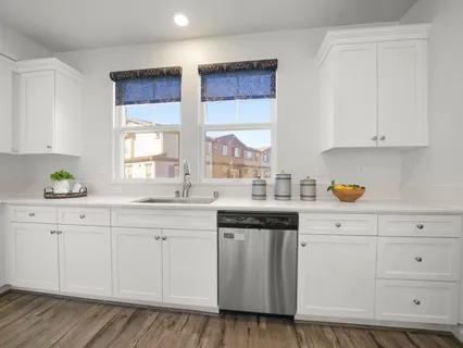a kitchen with granite countertop white cabinets and white appliances