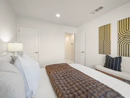 a bedroom with a bed and painting on the wall