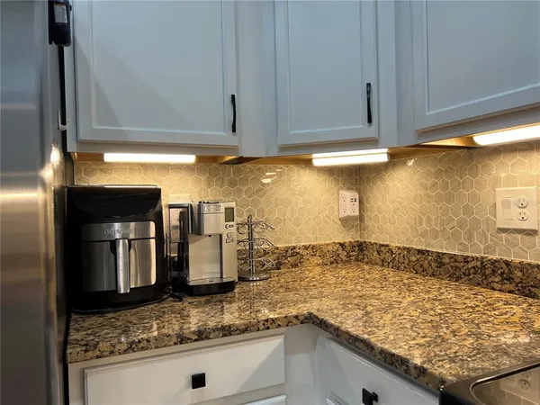 a kitchen with a sink and chairs
