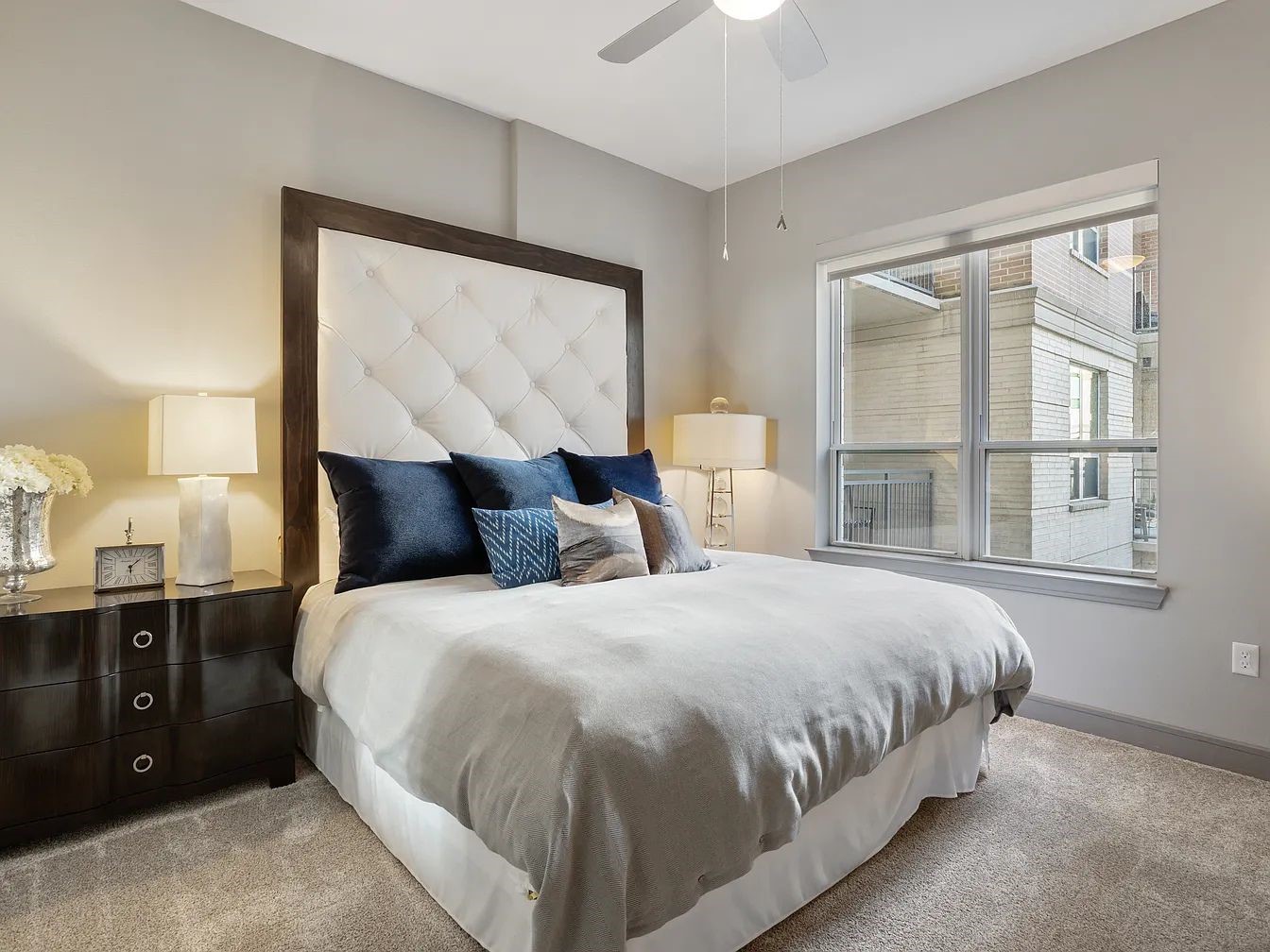 2724 Kipling Street, Unit 535 Houston, TX 77098 - Photo 29 of 30 Start your day by watching the city wake up from the comfort of your plush, featuring a stunning tufted, oversized headboard framed in dark wood, acting as the elegant anchor of the space.