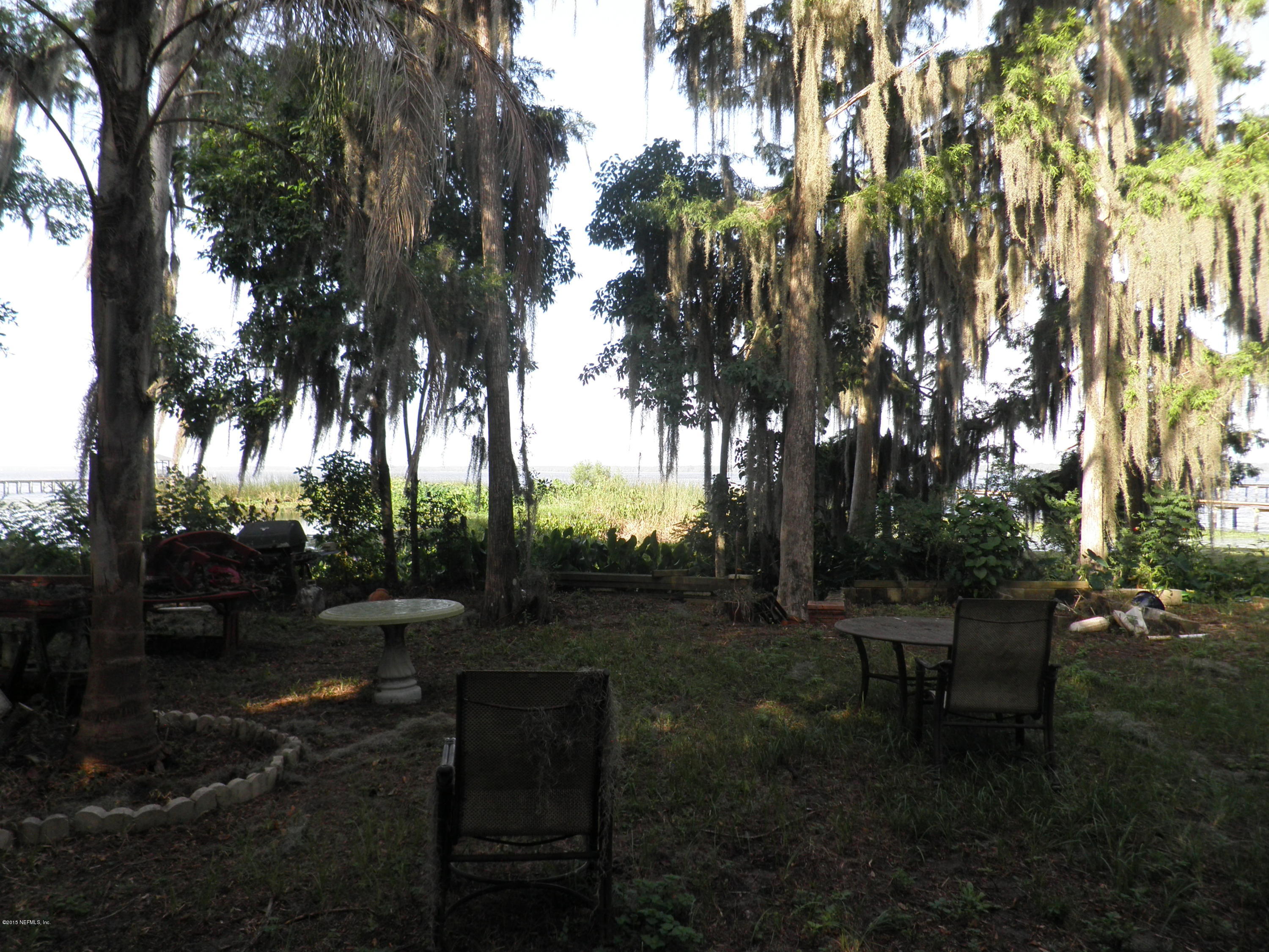 200 River's Edge Road South St. Augustine, FL 32092 - Photo 3 of 11 a backyard of a house with table and chairs floor to ceiling window and a fire pit