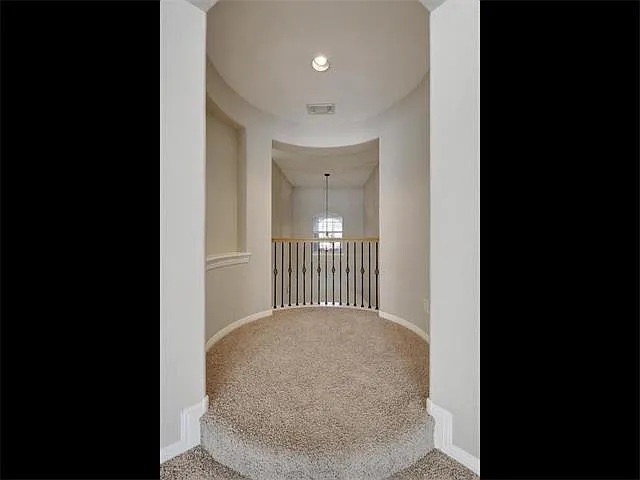 1832 Nelson Ranch Loop Cedar Park, TX 78613 - Photo 15 of 15 A graceful arched hallway leads to a carpeted landing with an elegant iron railing.