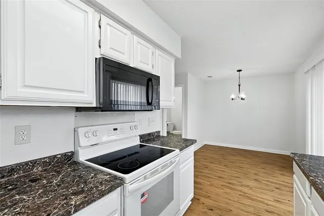 a kitchen with granite countertop a stove and a microwave