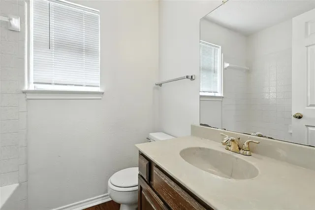 a bathroom with a sink toilet and a mirror
