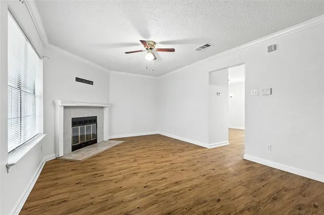 a view of empty room with wooden floor and fireplace
