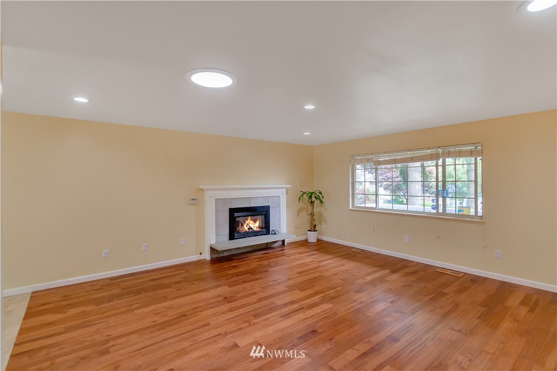 3726 199th Street Southeast Bothell, WA 98012 - Photo 7 of 18 an empty room with wooden floor and a fireplace