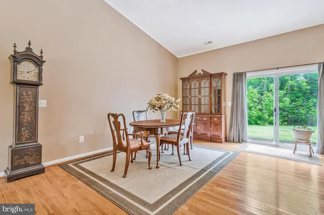 a dining room with stainless steel appliances kitchen island granite countertop a table chairs and a refrigerator