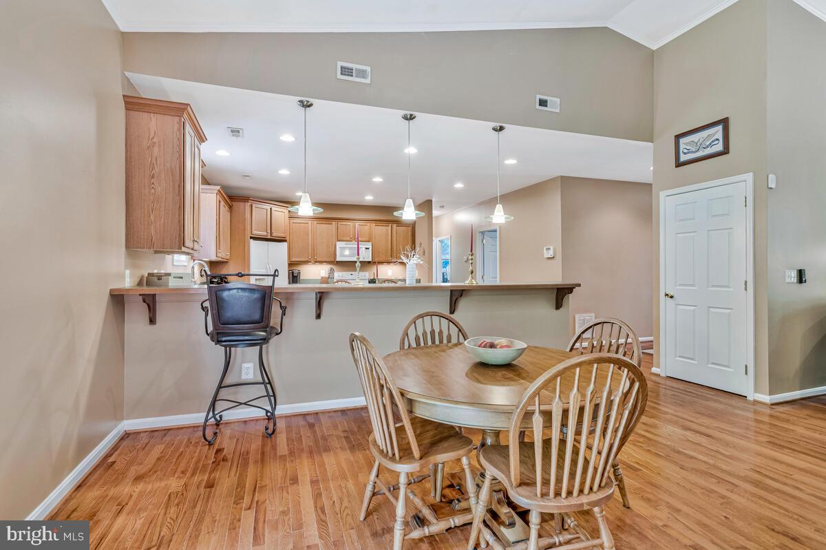 1955 Wilson Road Huntingtown, MD 20639 - Photo 14 of 45 a dining room with stainless steel appliances kitchen island granite countertop a table chairs and a refrigerator