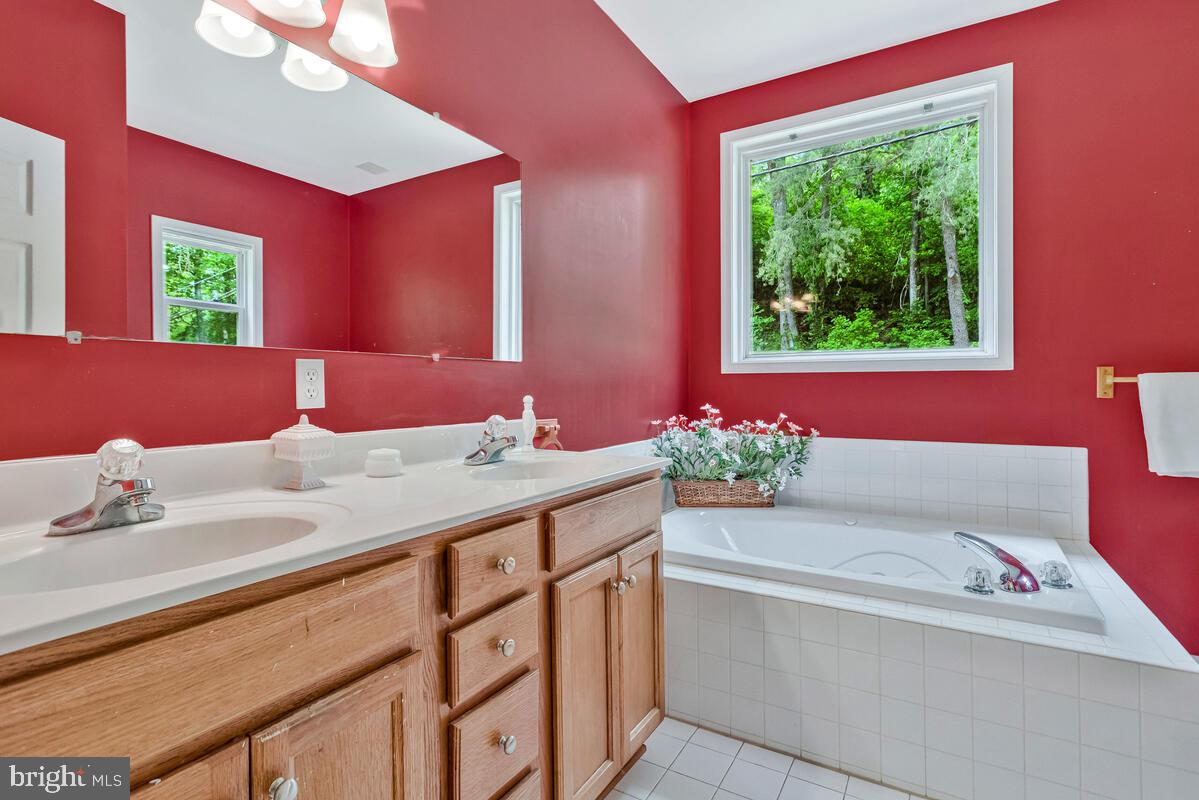 1955 Wilson Road Huntingtown, MD 20639 - Photo 21 of 45 a bathroom with a granite countertop sink and a large mirror