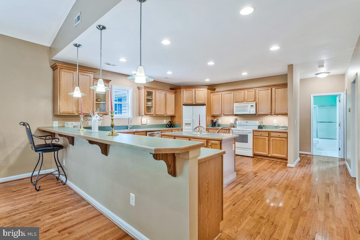 1955 Wilson Road Huntingtown, MD 20639 - Photo 5 of 45 a kitchen with stainless steel appliances granite countertop a sink a stove a refrigerator and island with wooden floor