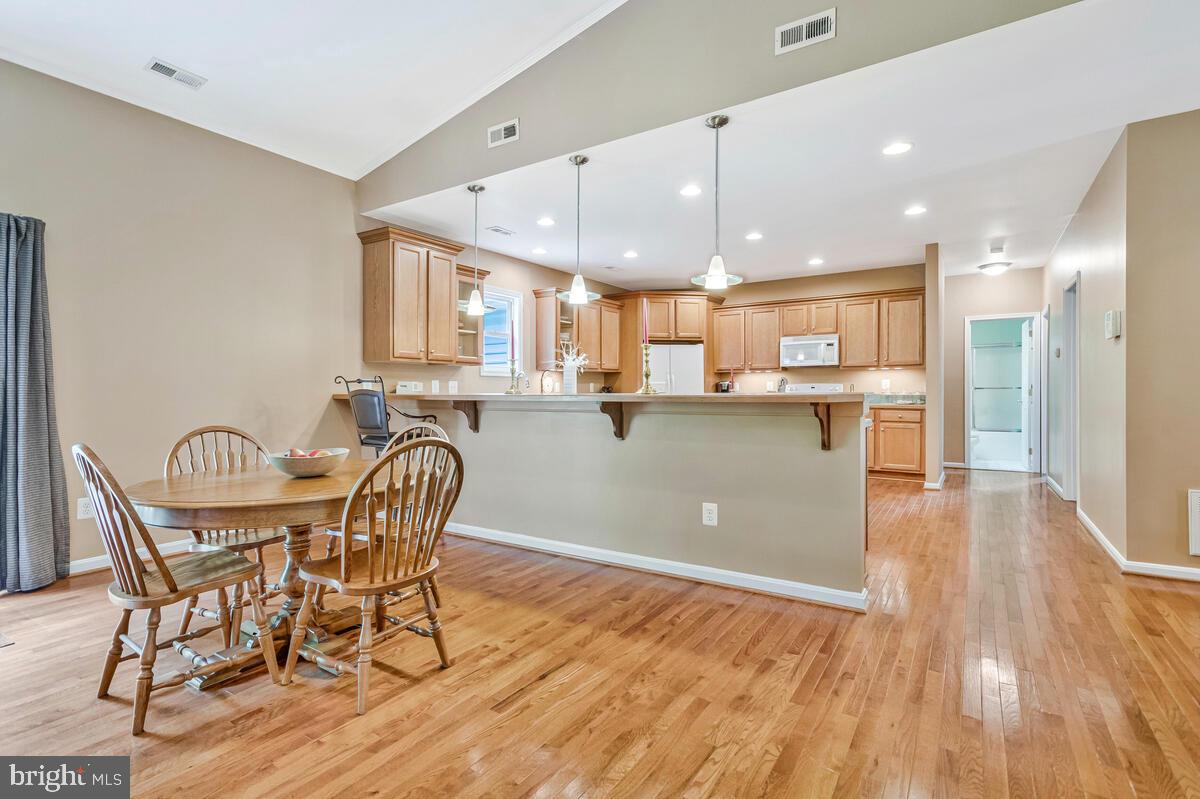 1955 Wilson Road Huntingtown, MD 20639 - Photo 6 of 45 a kitchen with stainless steel appliances kitchen island granite countertop a table chairs and a view living room