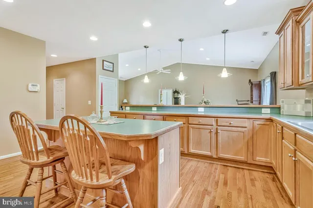 a kitchen with kitchen island granite countertop wooden floors and a sink