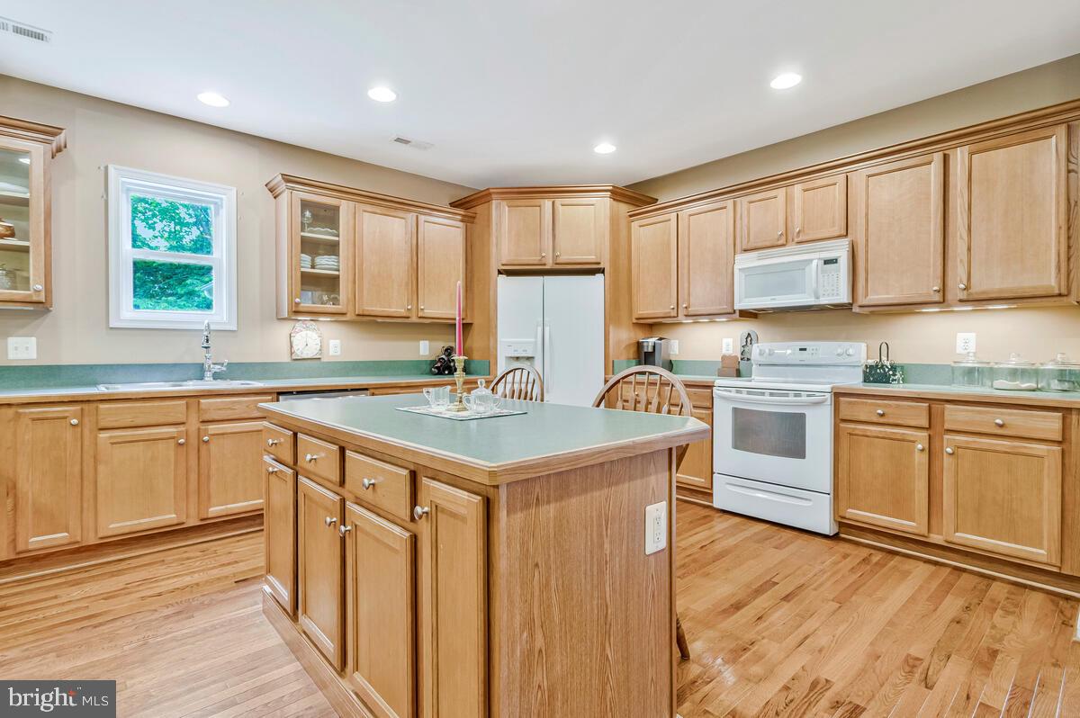 1955 Wilson Road Huntingtown, MD 20639 - Photo 10 of 45 a kitchen with stainless steel appliances granite countertop a stove a sink dishwasher and a refrigerator with wooden cabinets
