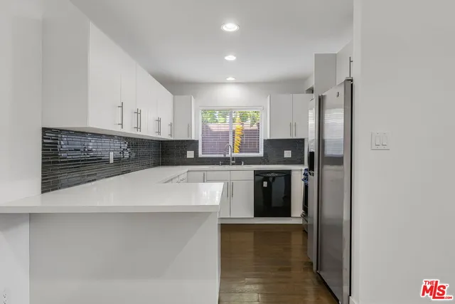 a kitchen with stainless steel appliances a refrigerator sink and stove