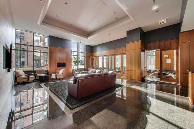 a living room with furniture kitchen view and a large window