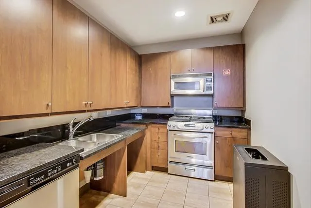 a kitchen with stainless steel appliances granite countertop a stove and a sink