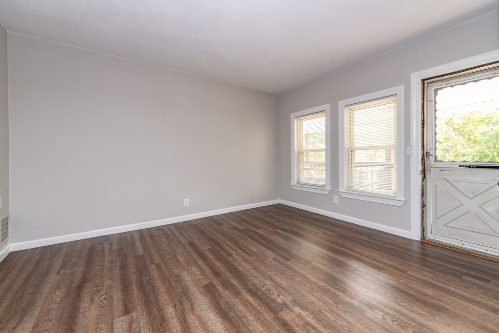 266-274 River Street Waltham, MA 02453 - Photo 12 of 27 a view of an empty room with wooden floor and a window