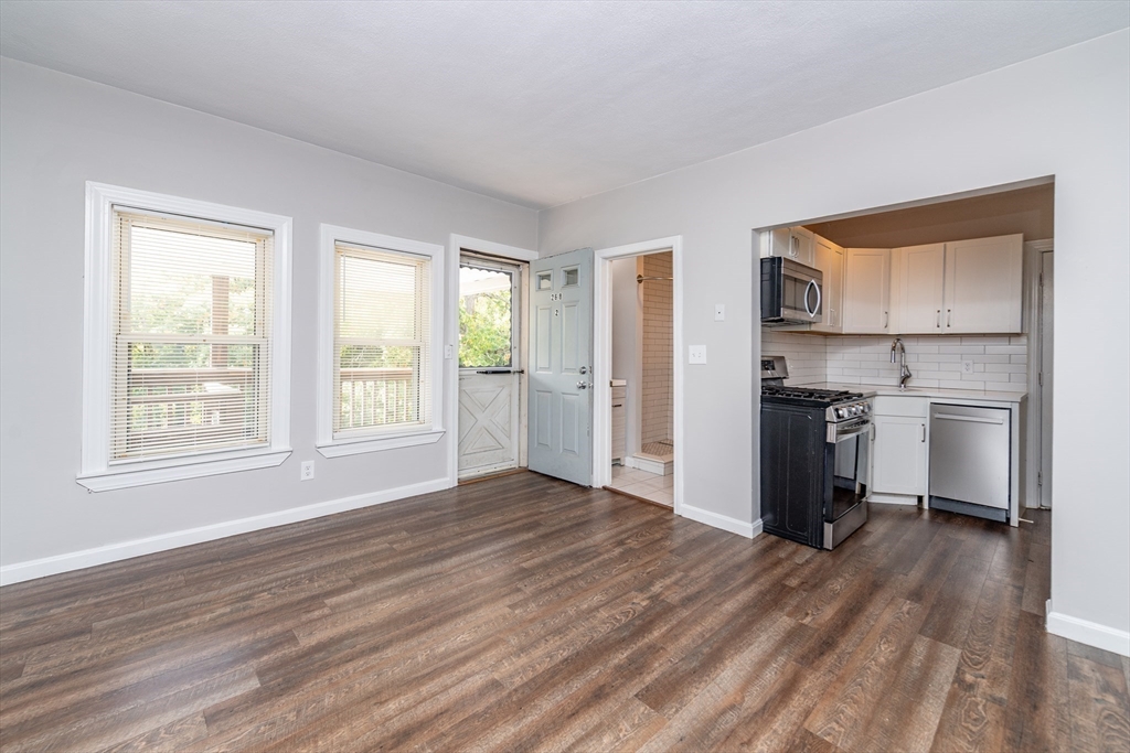 266-274 River Street Waltham, MA 02453 - Photo 13 of 27 a view of kitchen and empty room with wooden floor kitchen view
